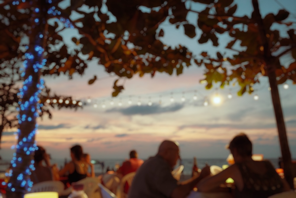 A bar with diners at dusk. Kamala Beach has a quieter but still active nightlife.